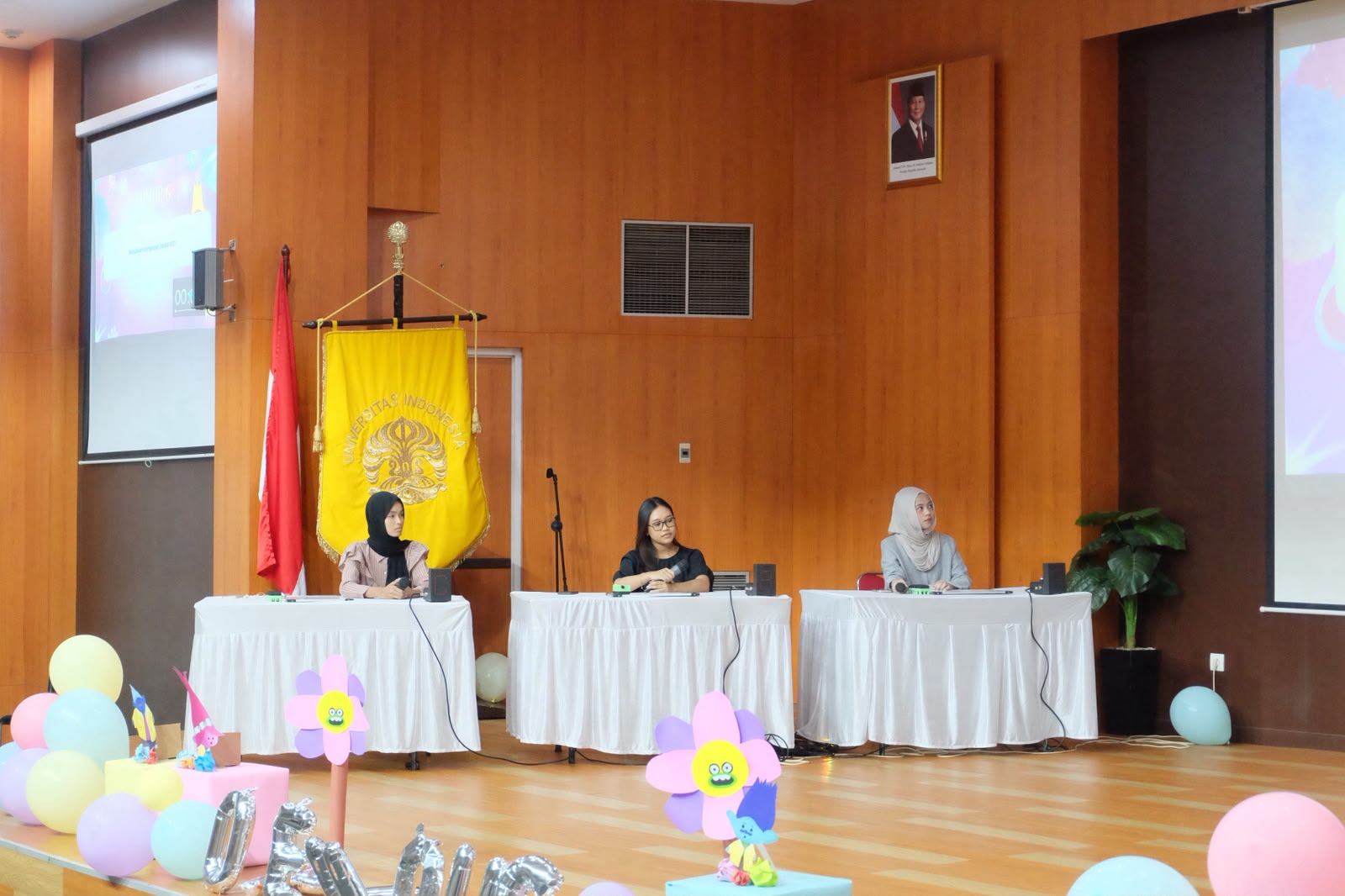 Tiga peserta DWBO duduk di meja lomba lengkap dengan bel jawaban di panggung